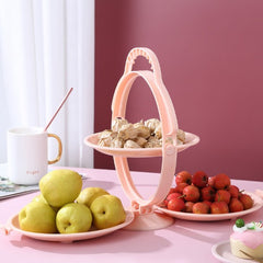 Image du Plateau à Fruits Pliable à Double Étage Quebekado, montrant ses deux niveaux en configuration dépliée. Disponible en couleurs rose, bleu et vert, ce plateau en ABS de haute qualité est affiché dans un intérieur moderne, mettant en valeur son design élégant et fonctionnel