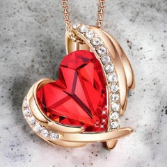 Collier Coeur d'Ange de chez Quebekado avec un cœur rouge vif de cristal Swarovski soutenu par les ailes d'un ange.