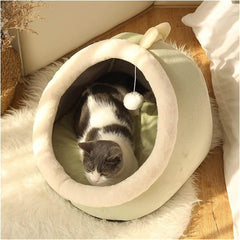 Maison Douillette pour Chat Quebekado, présentant un lit-tente confortable en flanelle douce avec une entrée triangulaire et des oreilles de lapin design. L'intérieur montre un coussin moelleux amovible, idéal pour le repos des chats. La tente est placée sur un sol lisse, illustrant sa base antidérapante et sa stabilité.